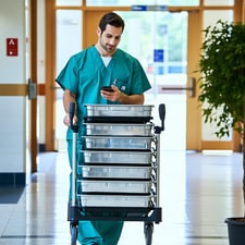 A surgical implant representative arriving at the hospital in scrubs or street clothes to deliver metal surgical implant procedure trays which are arranged on a reps personal collapsible cart for easy transport in and out of hospital As they navigate-1